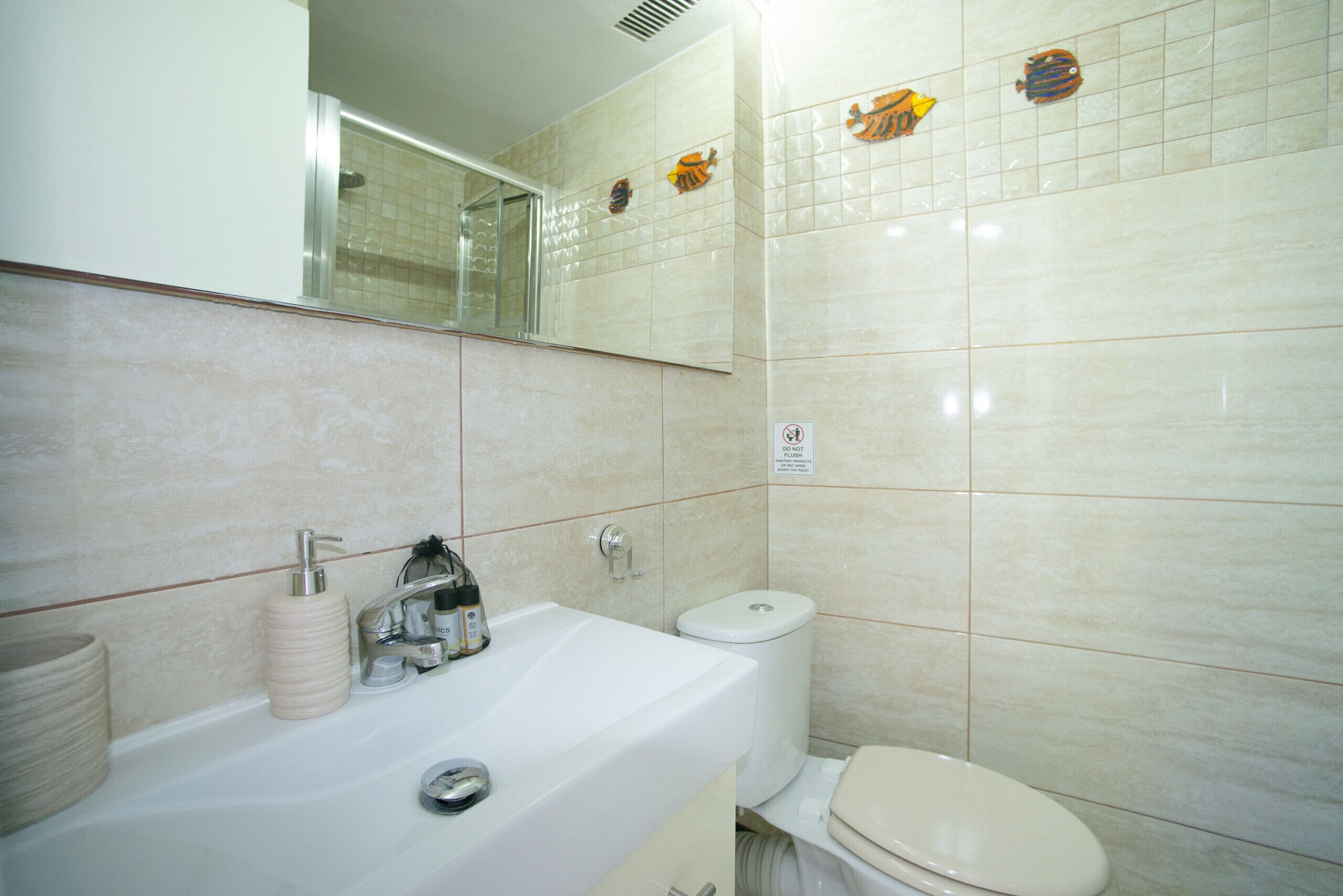 Un baño con lavabo, inodoro y espejo.