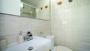 Un baño con lavabo, inodoro y espejo.
