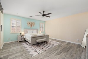 A bedroom with a bed, bedside tables, a ceiling fan, and a patterned rug. - Spacious 4-Bedroom Home ~ Backyard BBQ Oasis (Phoenix)