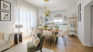 Et moderne spiseområde med et træbord, stole og et køkken i baggrunden.
