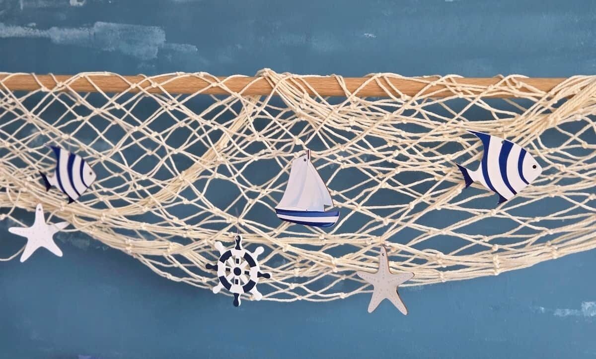 A macrame wall hanging with nautical decorations.