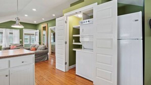 A kitchen with white cabinets, a built-in oven, and a refrigerator.