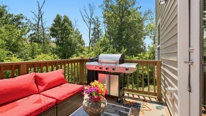 A deck with a barbecue grill, a red sofa, and a vase with flowers. - Stylish Antioch Stay Minutes to Downtown Nashville (Nashville)