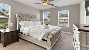A bedroom with a bed, nightstands, a dresser, a ceiling fan, and large windows. - Stylish Antioch Stay Minutes to Downtown Nashville (Nashville)