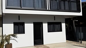 A modern two-story building with large windows, a flat roof, and a concrete ground. - Vista Mar Riviera - Terraço com Vista para o Mar a 50m da Praia da Ferrugem (Garopaba)