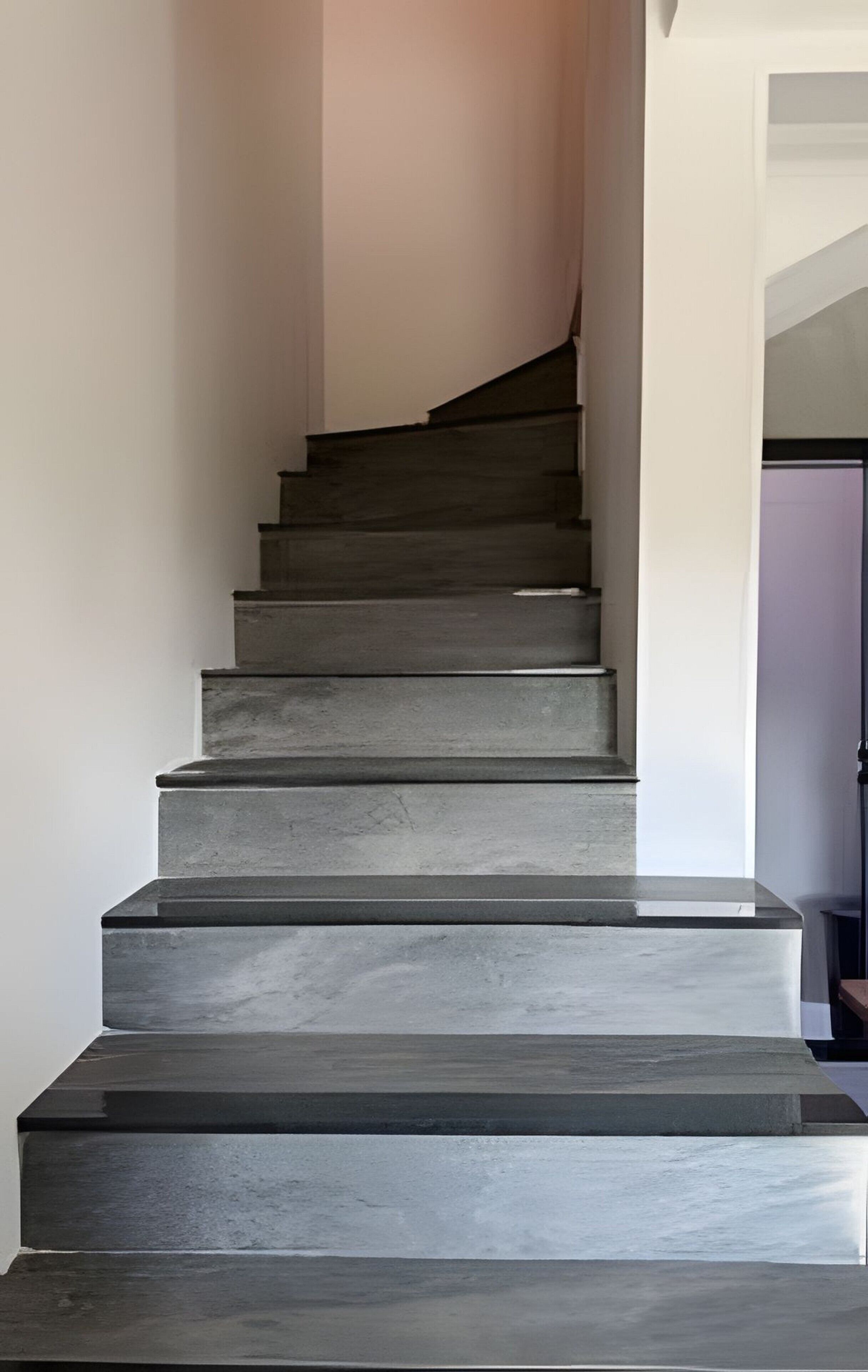 Uma escadaria com design moderno, que leva a um patamar.