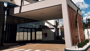 A modern hotel entrance with a covered walkway, a clear sky, and a visible ROTA HOTEL sign. - Rota Hotéis Rio Verde (Rio Verde)