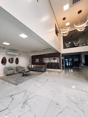 A spacious lobby with a marble floor, modern furniture, and contemporary lighting fixtures.