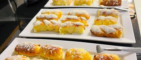 Un bufé con diversos pasteles y postres.