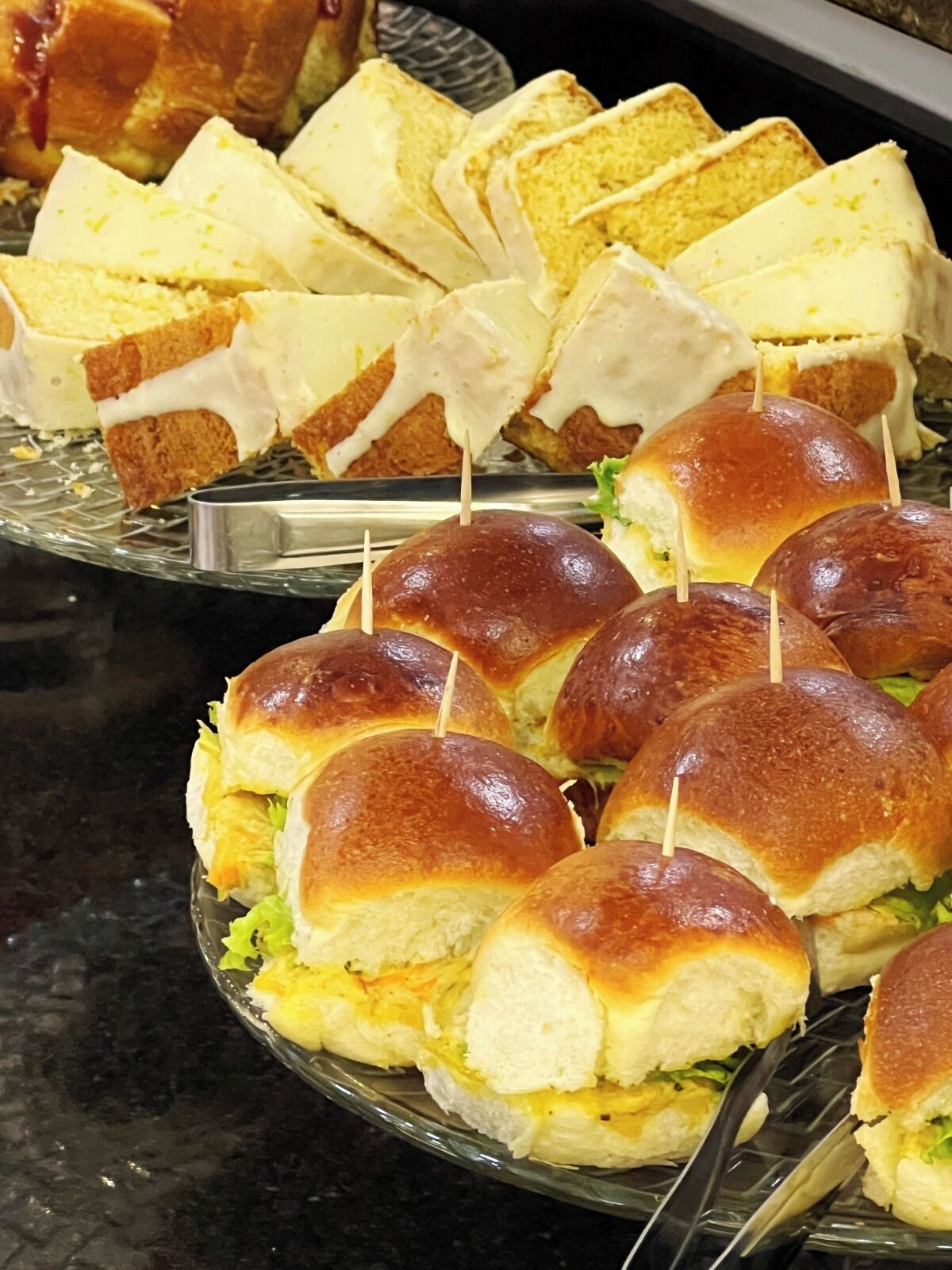 A buffet with sandwiches and a cake.
