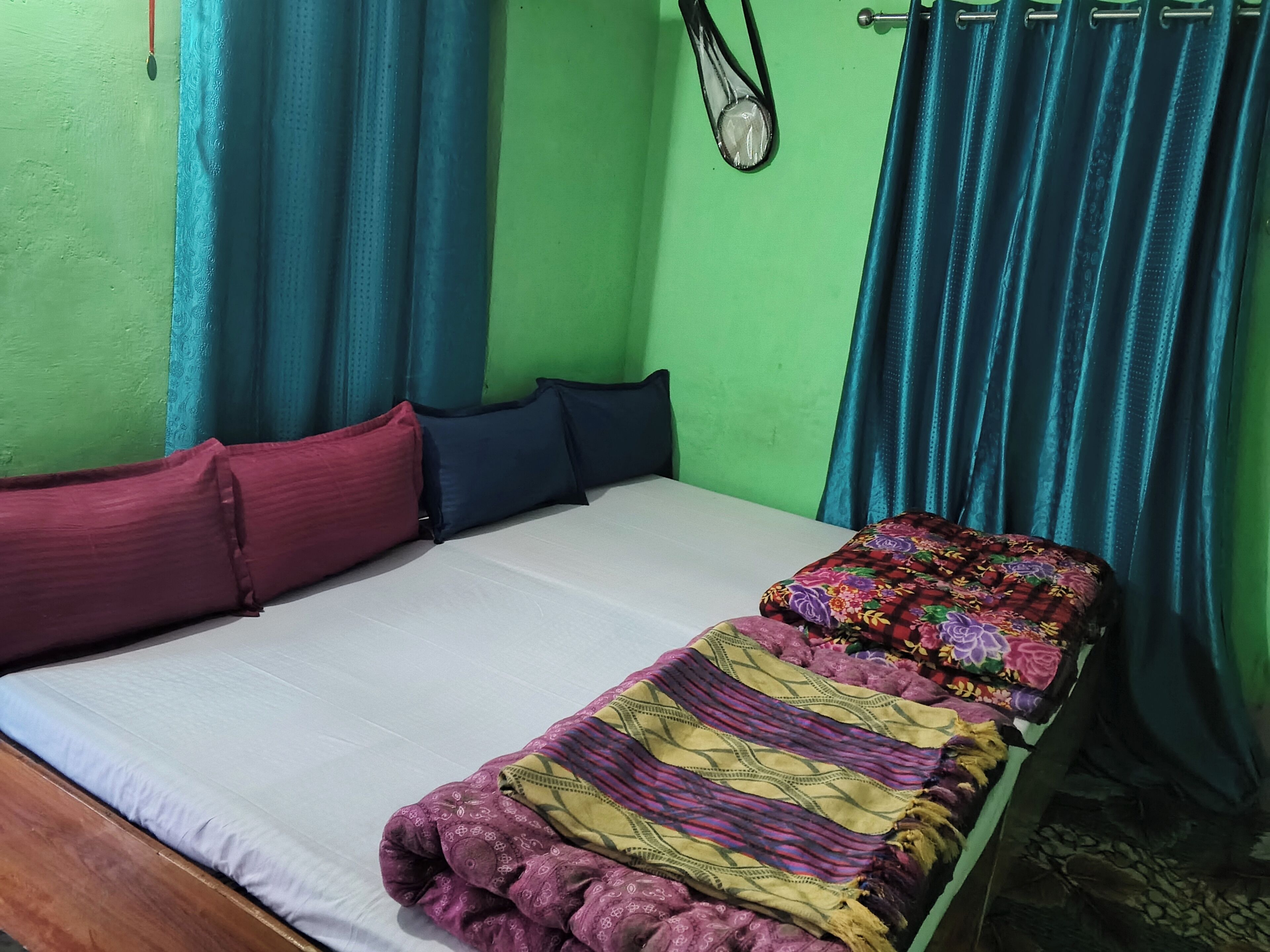 Ein Zimmer mit einem Bett, Vorhängen und einem Gegenstand an der Wand.