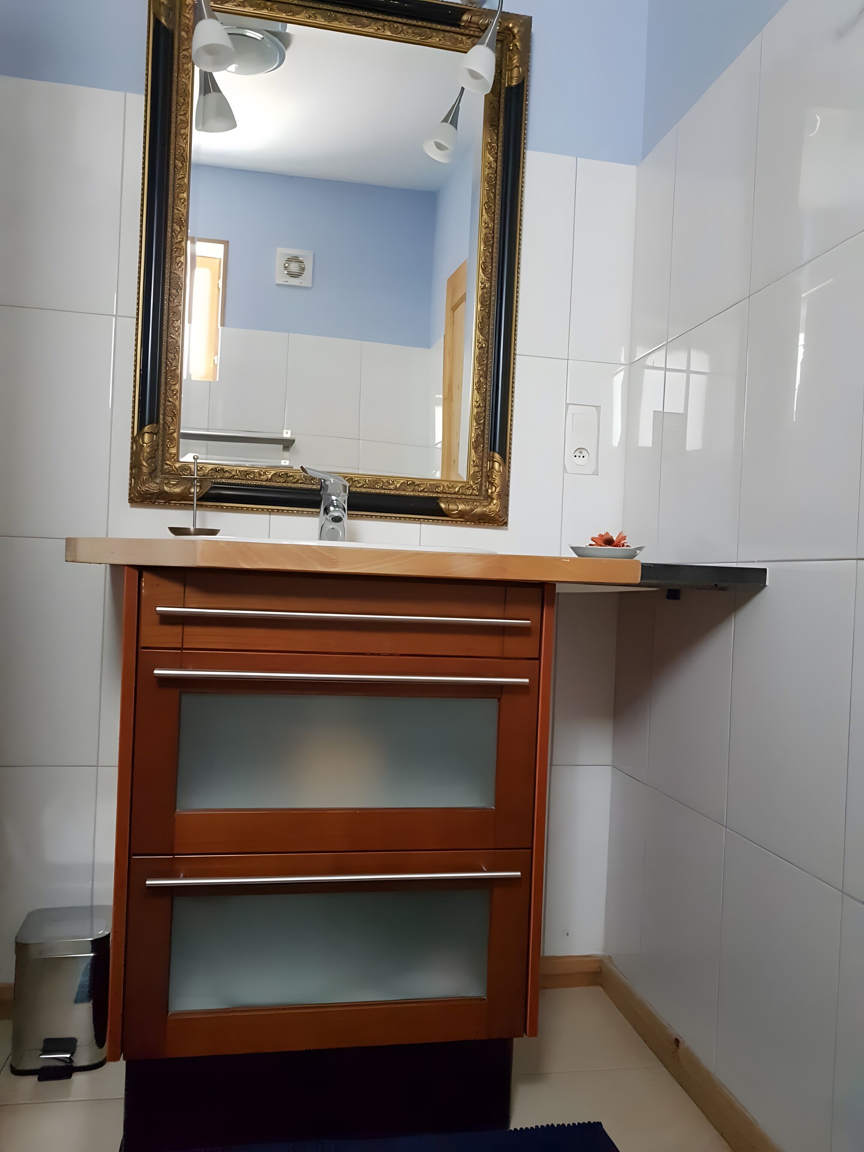 Une salle de bain avec un meuble-lavabo, un miroir et un évier.