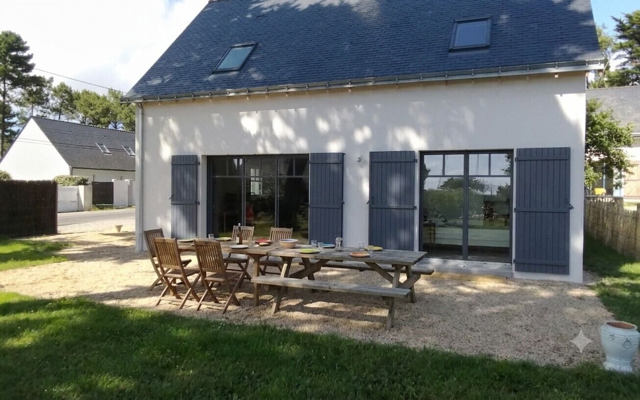 A house with a covered patio, a dining table, and chairs.