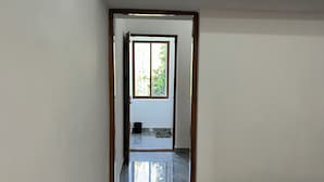 Un dormitorio con cama, una puerta que da a un balcón y suelo de mármol.