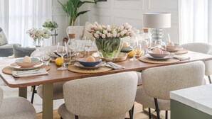 Ein Essbereich mit Holztisch, Stühlen und einem Blumenstrauß.
