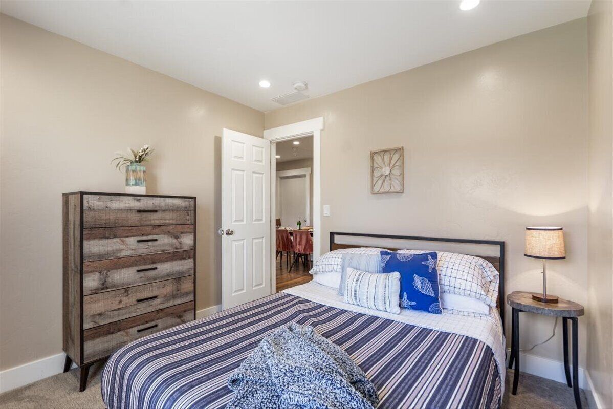 Cozy queen bedroom with rustic dresser and warm, inviting style