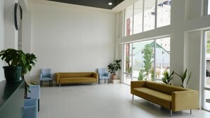 A spacious lobby with a yellow sofa, blue armchairs, and potted plants. - Toma Palace (Khelvachauri)