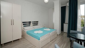 A bedroom with a bed, a wardrobe, a desk, and a chair. - Toma Palace (Khelvachauri)