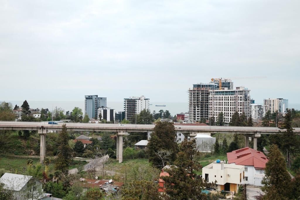 A cityscape with high-rise buildings, a bridge, and a body of water in the background.