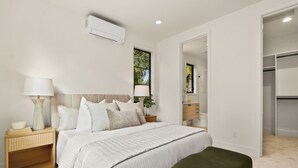 A bedroom with a bed, bedside tables, a lamp, a mirror, and a wardrobe. - Bright + Modern DADU near Downtown Kirkland - Garage/EV +Private yard (Kirkland)