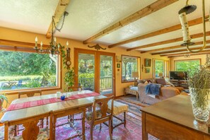 A cozy interior with a dining area, seating, and a view of the outdoors. - Whitefish Mountain Farmhouse | Near Glacier (Whitefish)