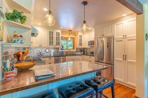 A modern kitchen with a central island, stainless steel appliances, and pendant lighting. - Whitefish Mountain Farmhouse | Near Glacier (Whitefish)