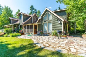 A two-story house with a stone patio and a front porch. - Whitefish Mountain Farmhouse | Near Glacier (Whitefish)