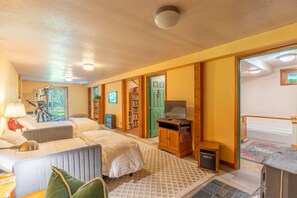 A room with a bed, a desk, a bookshelf, and a door leading to another room. - Whitefish Mountain Farmhouse | Near Glacier (Whitefish)