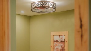 A wooden bed in a room with a green wall and a framed picture.