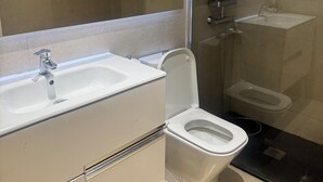 A modern bathroom with a glass-enclosed shower, a white sink, and a toilet. - Guipuzcua  (Pamplona)