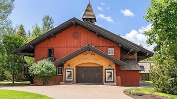 Un bâtiment rouge avec une enseigne indiquant « Opéra » et un petit balcon.