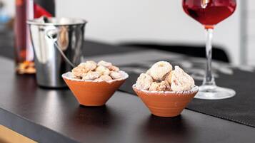 A table with a bottle, a glass, and two bowls of ice cream.