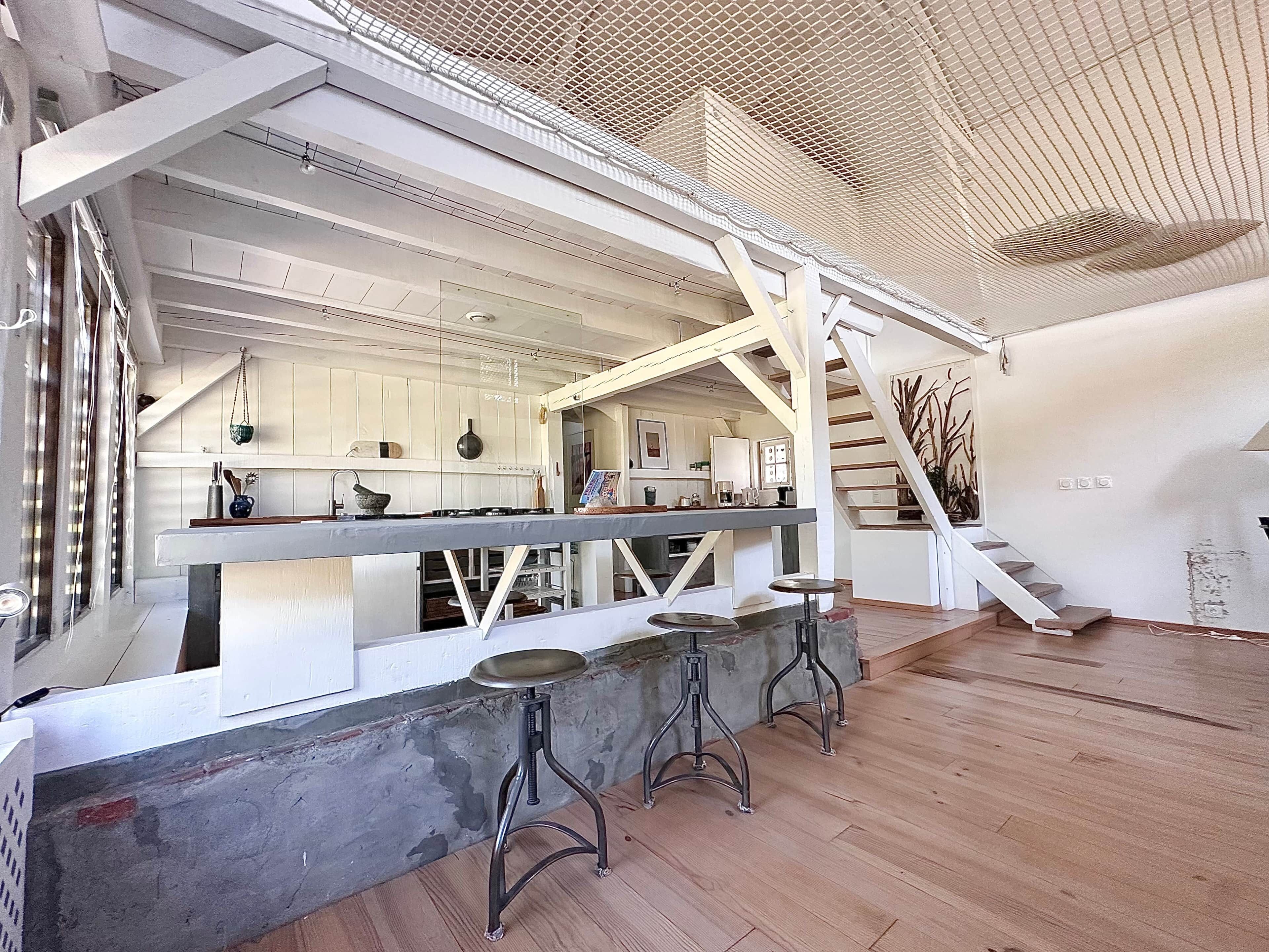 Ein modernes Interieur mit Küche, Bar und Treppe.