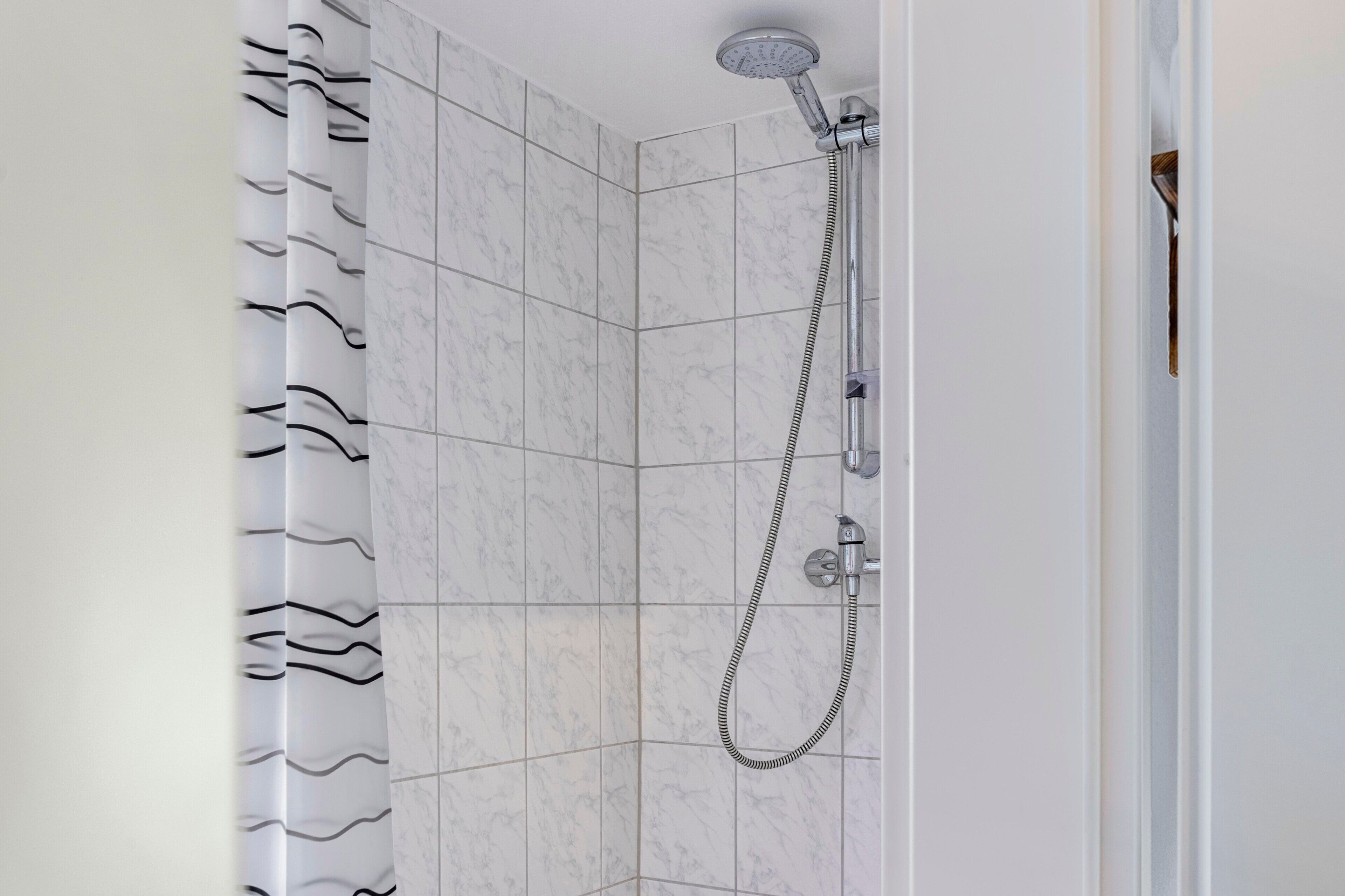 Eine Eckdusche mit Handbrause und flexiblen Duschschlauch.