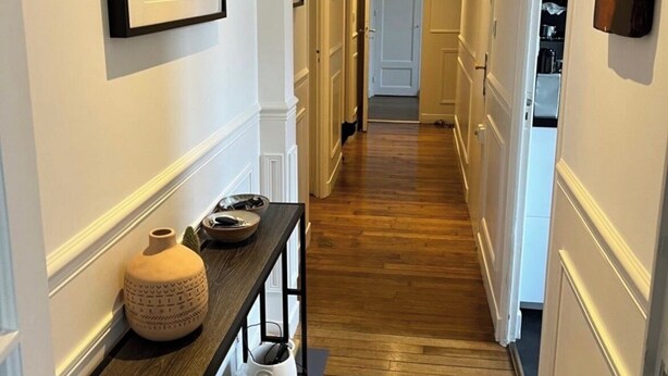 A hallway with wooden flooring, white walls, and framed artwork. - 90-square-meter apartment in the city center, 10 minutes from the train station, 200 meters from the cathedral (Quimper)