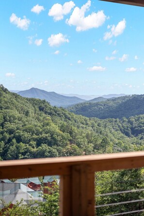 A view of a mountainous landscape with dense forest and a clear sky. - Grand Splash Cabin | Hot Tub, Pool, View, GAMES! (Sevierville)