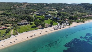 An aerial view of a coastal resort with multiple buildings, a beach, and clear blue waters. - AZURE RESIDENCE KOUMITSA (Koumitsa)