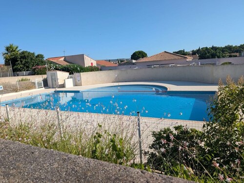House in a gated community with a pool, tennis court, and playground.