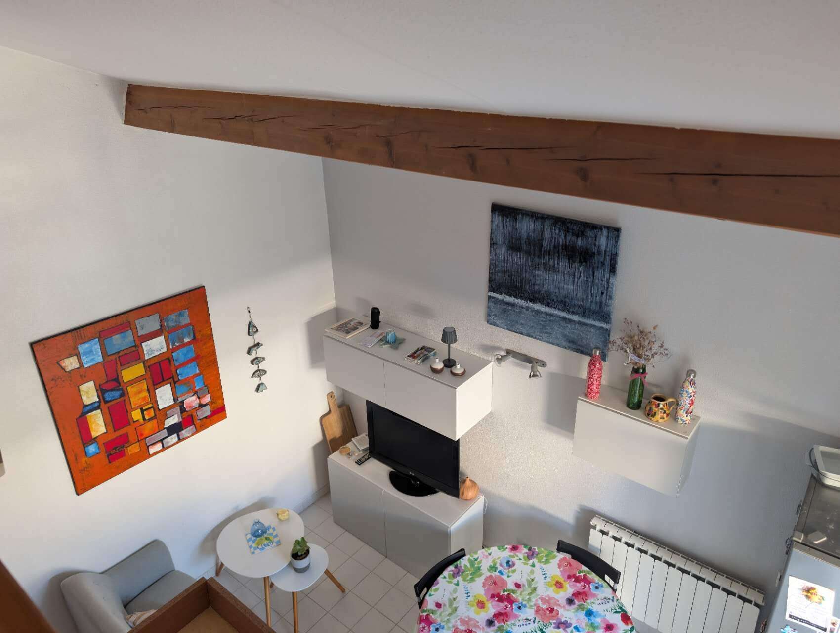 Ein kompakter Wohnbereich mit Küchenzeile, Essbereich und Fernseher.