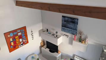 Ein kompakter Wohnbereich mit Küchenzeile, Essbereich und Fernseher.