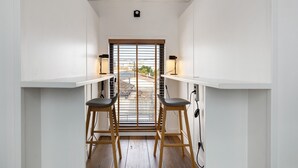 A narrow hallway with a window, two stools, and a table. - Holiday Home 'Esprit Chic-Calme-Climatisation' with Private Garden, Wi-Fi and Air Conditioning (Pessac)