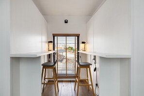 A narrow hallway with a window, two stools, and a table. - Holiday Home 'Esprit Chic-Calme-Climatisation' with Private Garden, Wi-Fi and Air Conditioning (Pessac)