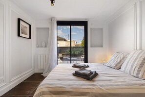 A bedroom with a bed, a radiator, a framed picture, and a view of the outside. - Holiday Home 'Esprit Chic-Calme-Climatisation' with Private Garden, Wi-Fi and Air Conditioning (Pessac)