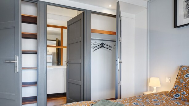 A bedroom with a bed, a bedside table, a lamp, and a wardrobe with a mirror. - Holiday Home 'Esprit Chic-Calme-Climatisation' with Private Garden, Wi-Fi and Air Conditioning (Pessac)