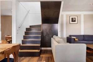 Un intérieur moderne comprenant un escalier, un coin repas et un salon.