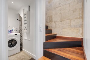 A laundry room with a washing machine, a drying rack, and a small shelf with cleaning supplies. - Holiday Home 'Esprit Chic-Calme-Climatisation' with Private Garden, Wi-Fi and Air Conditioning (Pessac)