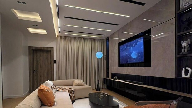 A modern living room with a sofa, coffee table, and a TV mounted on the wall. - Chulis Apartment  (Galadimawa)