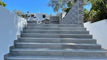 A set of grey stone steps leading up to a building with a white exterior.