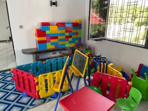 Ein Spielbereich mit bunten Bauklötzen, einer Tafel und einem kleinen Tisch.