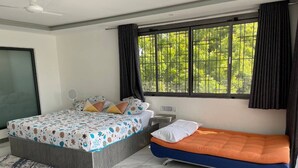 A bedroom with a bed, a sofa bed, a window with curtains, a ceiling fan, and a tiled floor. - A Luxurious 5-Bedroom Kids friendly Private Villa in the Heart of Watamu. (Kilifi)
